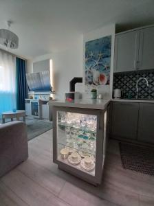 a kitchen with a glass case with dishes in it at Apartament Jantar Park in Jantar