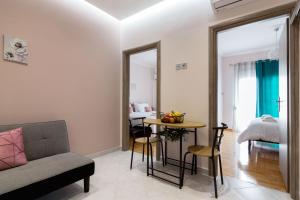 Sirens Athens Apartment في أثينا: غرفة معيشة مع أريكة وطاولة