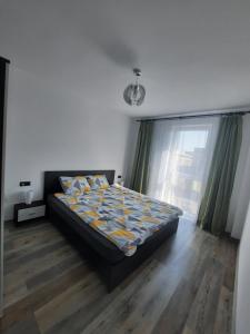 a bedroom with a bed and a large window at Apartament Coco in Baia Mare