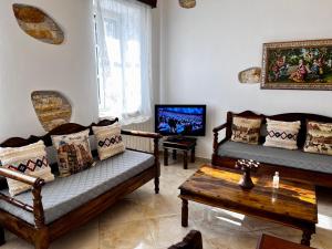 a living room with two couches and a tv at PETRA HOME heritage and hospitality in Apeiranthos
