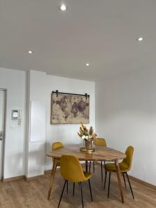 a dining room with a wooden table and yellow chairs at Charmant T2 refait à neuf in Ajaccio