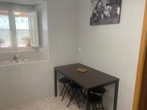a kitchen with a table and stools in a room at Casa Rural La Corrada in Llamoso +27 photos