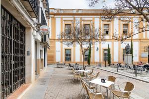 Un patio con mesas y sillas en un edificio. en Apartamentos El balcón de la Trinidad Córdoba - GREAT LOCATION, en Córdoba