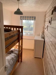 a bedroom with a bunk bed and a window at Ivory Lane in Trearddur