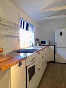 BlankaholmにあるGalleri huset studioのキッチン(白い家電製品、白い冷蔵庫付)