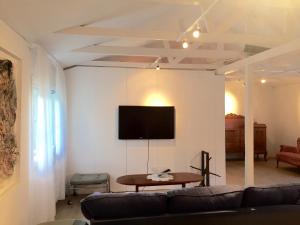 a living room with a couch and a tv on a wall at Galleri huset studio in Blankaholm