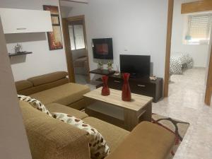 a living room with two red vases on a table at Casa Rural La Corrada in Llamoso