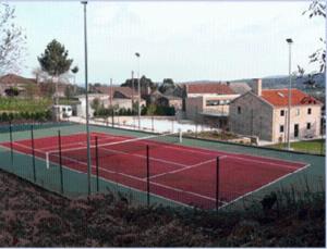 a tennis court in front of a town with houses at Casa rural A Mimoseira in A Estrada