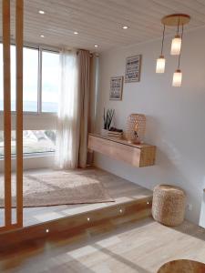 ein Wohnzimmer mit einem Tisch und einem Fenster in der Unterkunft Magnifique Studio Face Mer avec Place Privative. in Saint-Jean-de-Monts
