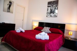 a bedroom with a red bed with towels on it at Etna Catania Center in Catania