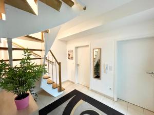 a hallway with stairs and a potted plant at Stadtwohnung am Oertelplatz in Munich