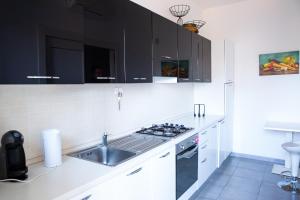 a kitchen with a sink, stove, and refrigerator at Etna Catania Center in Catania