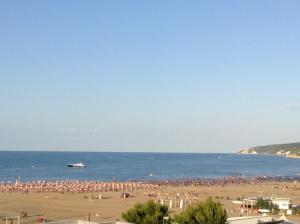 una spiaggia affollata con una grande folla di persone di Hotel Borgo Marina a Rodi Garganico