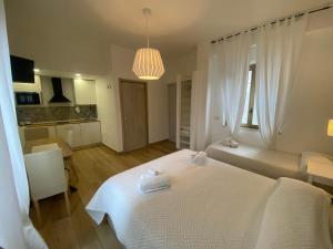 a bedroom with a white bed with towels on it at B&B Casa al Vicolo 2 in Taormina