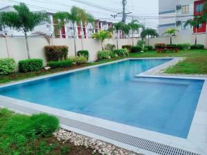 a swimming pool with blue water in a yard at 2-Bedroom Condo in Imus Cavite with UNLI WIFI, 50" TV, Netflix, Xbox One, Pool in Imus