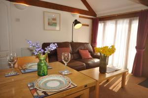 a living room with a table and a couch at Bowgie at Trewerry Cottages - Away from it all, close to everywhere in Newquay