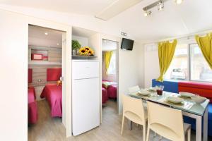cocina pequeña y comedor con mesa y sillas en Casa mobile - Eden Camping Village, en San Felice del Benaco