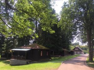 un petit bâtiment dans l'herbe à côté d'une route dans l'établissement Chatový areál Zděřina, à Police nad Metují