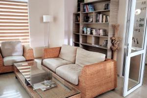 a living room with a couch and a chair and a table at Уютен апартамент близо до морето IGROEG in Burgas City