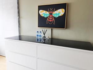 a painting of a bee on a wall with two bottles of water at Charming London Town Studio Flat, Tower Bridge in London