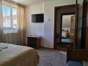- une chambre d'hôtel avec un lit et un miroir dans l'établissement Pensiunea Casa Domniței Sucevița, à Suceviţa