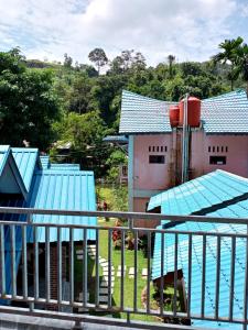 
a blue and white building next to a fence at Thomas' Retreat Bukit Lawang in Bukit Lawang
