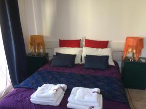 1 dormitorio con 1 cama con toallas en Vangelios Apartments, en Pafos