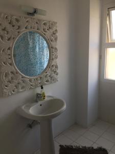 a bathroom with a sink and a mirror on the wall at Vangelios Apartments in Paphos