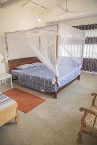1 dormitorio con 1 cama con mosquitera en Kodi Beach Home, en Galle