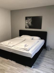 Marchica Apartment Nador Jadid Wifi Klima في الناظور: سرير في غرفة نوم مع إطار سرير أسود