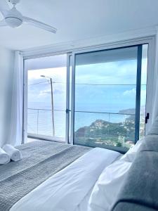 een slaapkamer met een bed en een groot raam bij Villa Cassolino in Ribeira Brava