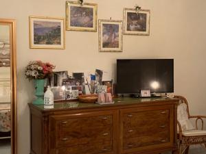 a television on top of a wooden dresser at B&B Paradiso San Vincenzo in Molfetta
