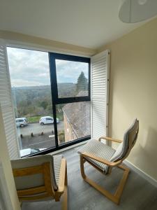 a room with two chairs and a large window at Hodge Bower Holidays - Ironbridge, Squires in Ironbridge
