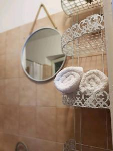 specchio e asciugamani su un appendiabiti in bagno di The White House Lumbarda a Lumbarda (Lombarda)