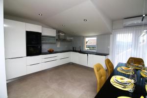 a kitchen with white cabinets and a table and chairs at Grande Rosa in Vrulje