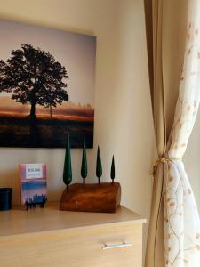 a wall with a picture of a tree on a shelf at GLI ALBERI apartment with view in Montepulciano