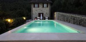 una piscina frente a una casa por la noche en CASOLARE PANORAMICO IN UMBRIA Casetta en Città di Castello