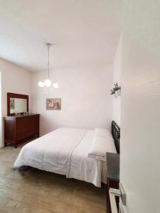 a white bedroom with a bed and a dresser at La Terrazza Sul Blu in Corniglia