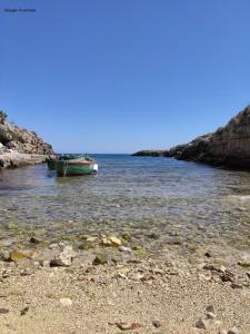 a boat sitting in the water next to a beach at Casa Marianna Short Lets in Polignano a Mare