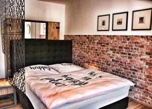 a bedroom with a bed with a brick wall at Kinzigloft nahe Frankfurt in Gelnhausen