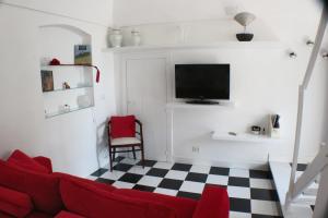 een woonkamer met een rode bank en een geruite vloer bij Dolce Loft in Bari