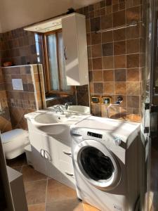 a bathroom with a washing machine and a sink at Residence Dolomiti in Forni di Sopra