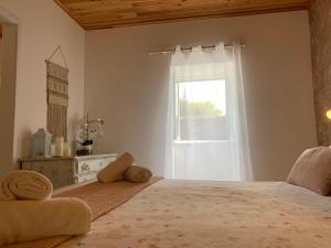 a bedroom with a large bed and a window at Casa do Priolo - Villaverde Azores in Feteiras