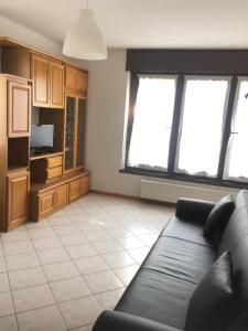 a living room with a couch and some windows at Paradiso sul lago in Calceranica al Lago