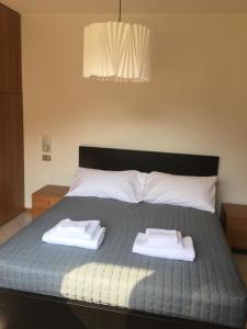 a bedroom with a bed with two towels on it at Paradiso sul lago in Calceranica al Lago