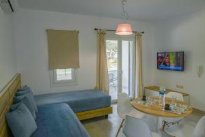 a living room with a bed and a table with chairs at Nissea Apartments in Naxos Chora