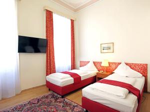 ein Hotelzimmer mit 2 Betten und einem TV in der Unterkunft HPA Hotel Andreas in Wien
