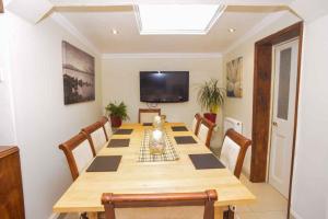 une salle à manger avec une grande table et des chaises en bois dans l'établissement pedro host family, à Londres