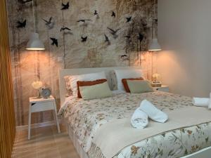 ein Schlafzimmer mit einem Bett mit Vögeln an der Wand in der Unterkunft Casa do Milhafre - Villaverde Azores in Feteiras + 53 Fotos