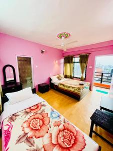 - une chambre dotée d'un lit avec un mur rose dans l'établissement Hotel Santana, à Pokhara